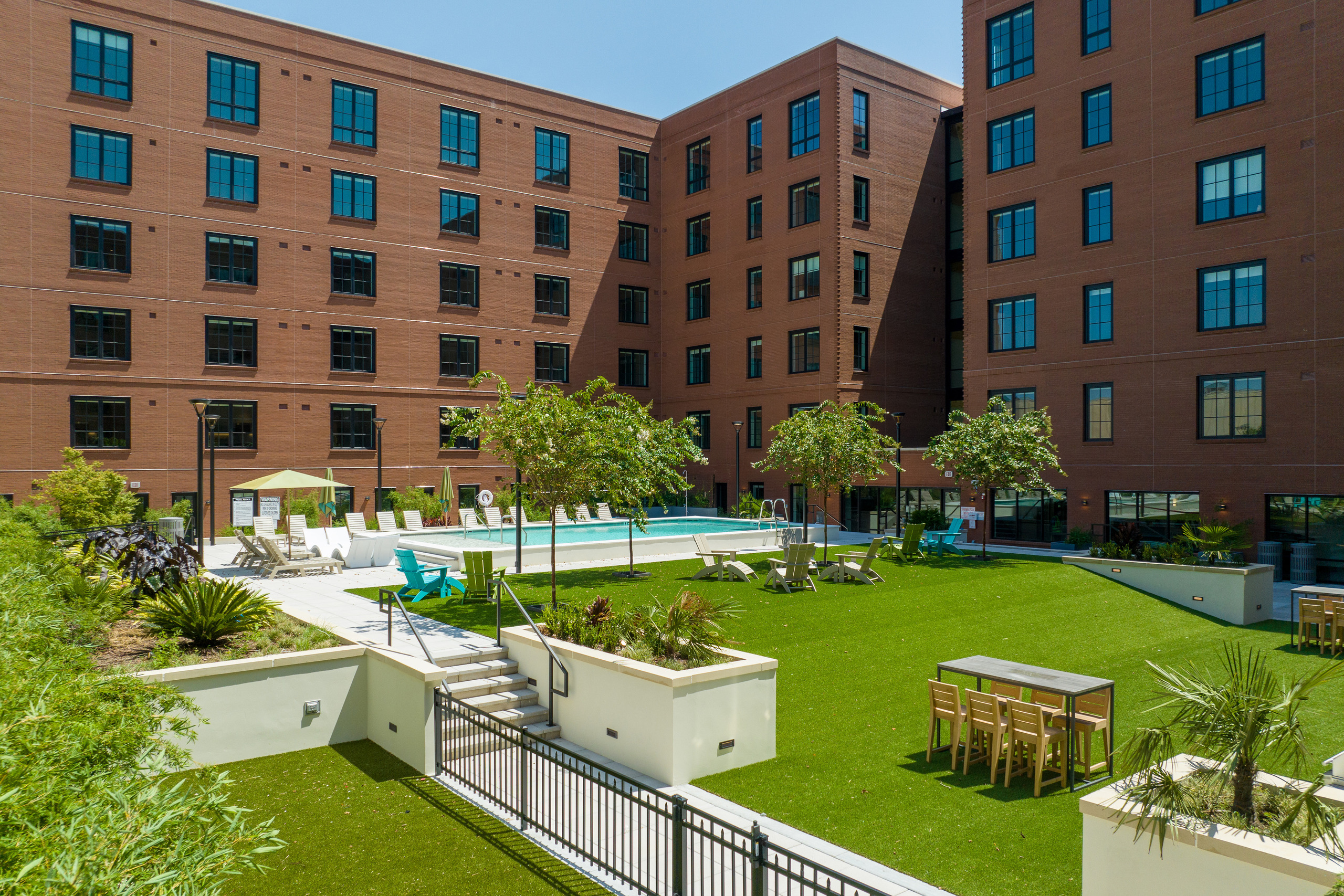 Daylight view across the landscaped courtyard and pool between the brick wings of 111 Ann Street.